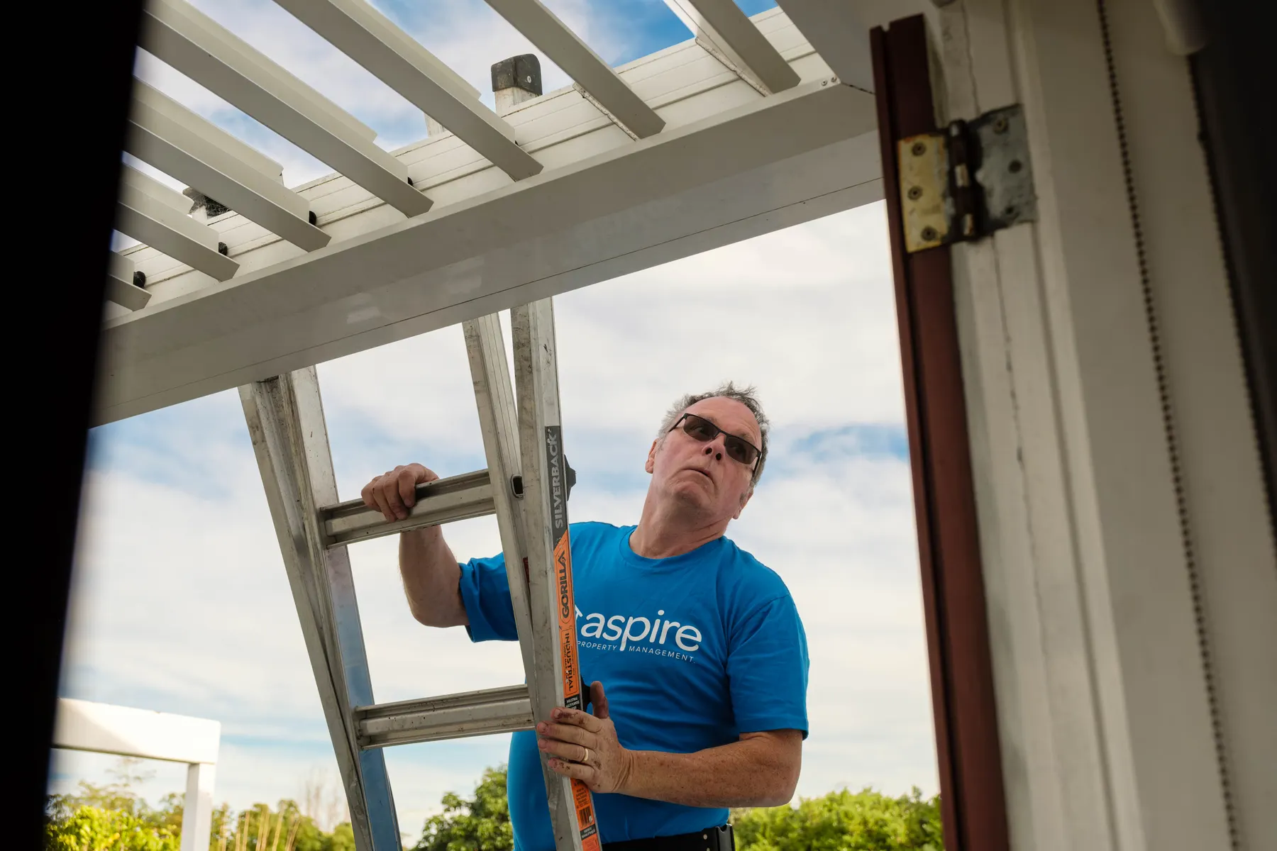 Don from Aspire Property Maintenance on a ladder checking a pergola
